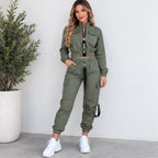 Women’s olive green utility jogger two-piece set with cropped zip jacket, cargo pockets, elastic jogger cuffs, and black strap details.