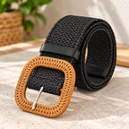 Black: Black woven elastic belt rolled up, showing a tan textured buckle, black keeper loop, and silver-tone pin.