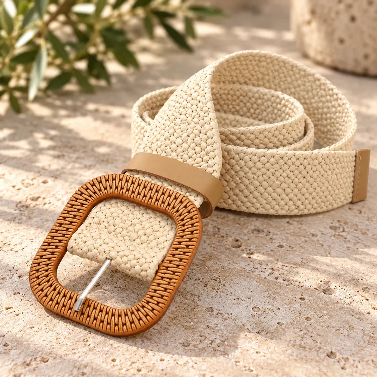 White: Cream-white woven elastic belt loosely coiled, showing a tan rounded-square buckle and keeper loop.