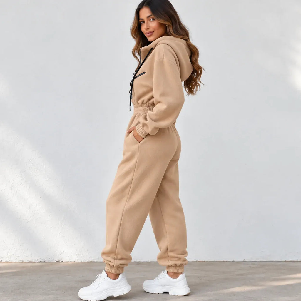 Side view of a beige fleece zip-up hoodie with black drawstrings, black zippers, and silver metal ring hardware.