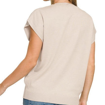 Woman wearing a beige short-sleeve top and blue jeans on a white background
