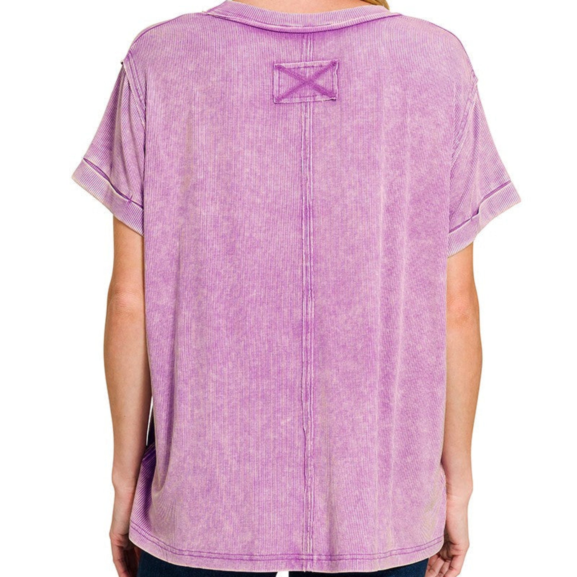 Person wearing a purple t-shirt with a logo on the back against a white background