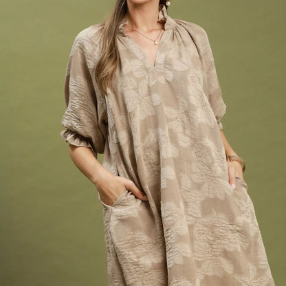 Front view of a loose flowing taupe Umgee V-neck dress with woven floral jacquard texture from Solazura Boutique