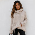 Woman wearing an apricot oversized knit cowl neck pullover with long sleeves and drawstring neckline