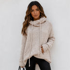 Woman wearing an apricot oversized knit cowl neck pullover with long sleeves and drawstring neckline