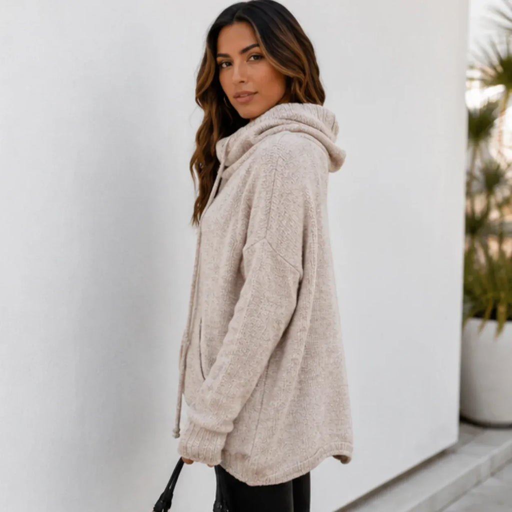 Side view of woman wearing an apricot oversized knit cowl neck pullover with relaxed fit and long sleeves