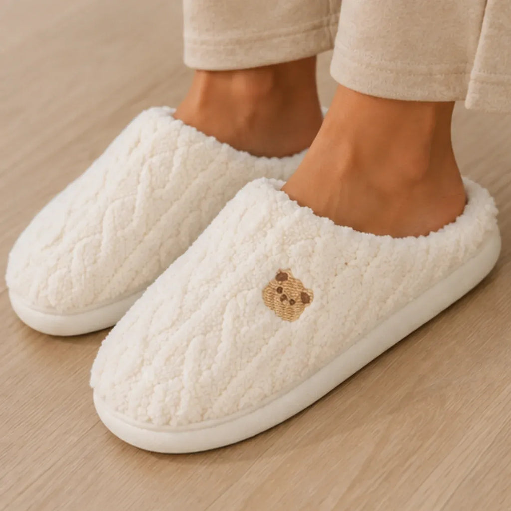 Close-up of the Aspen Cozy Knit House Slippers in white featuring plush sherpa texture, embroidered bear detail, and durable TPR sole.