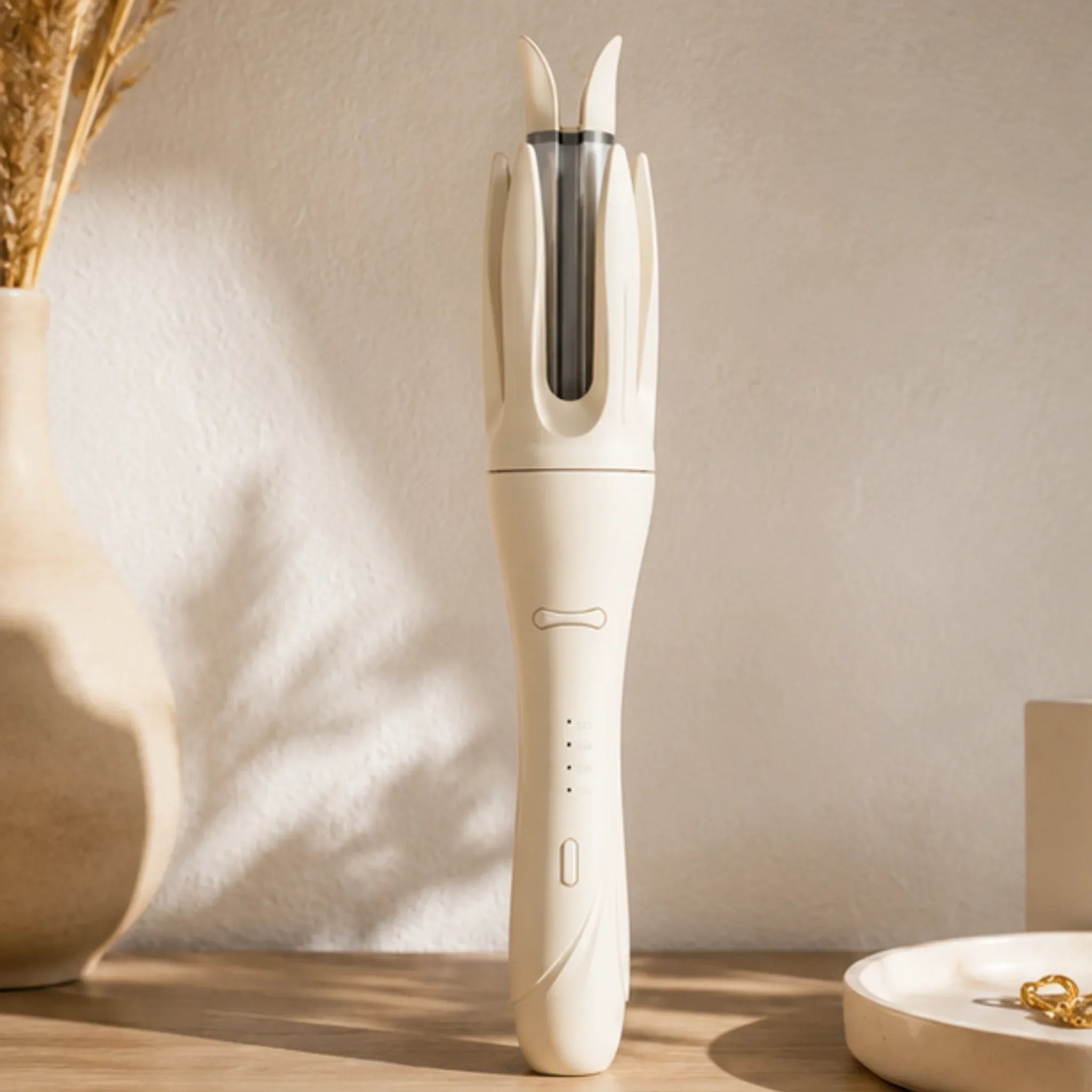 Ivory automatic rotating curling iron standing on a vanity with modern home décor.