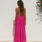 Back view of a women's hot pink backless cami maxi dress featuring an open back design.