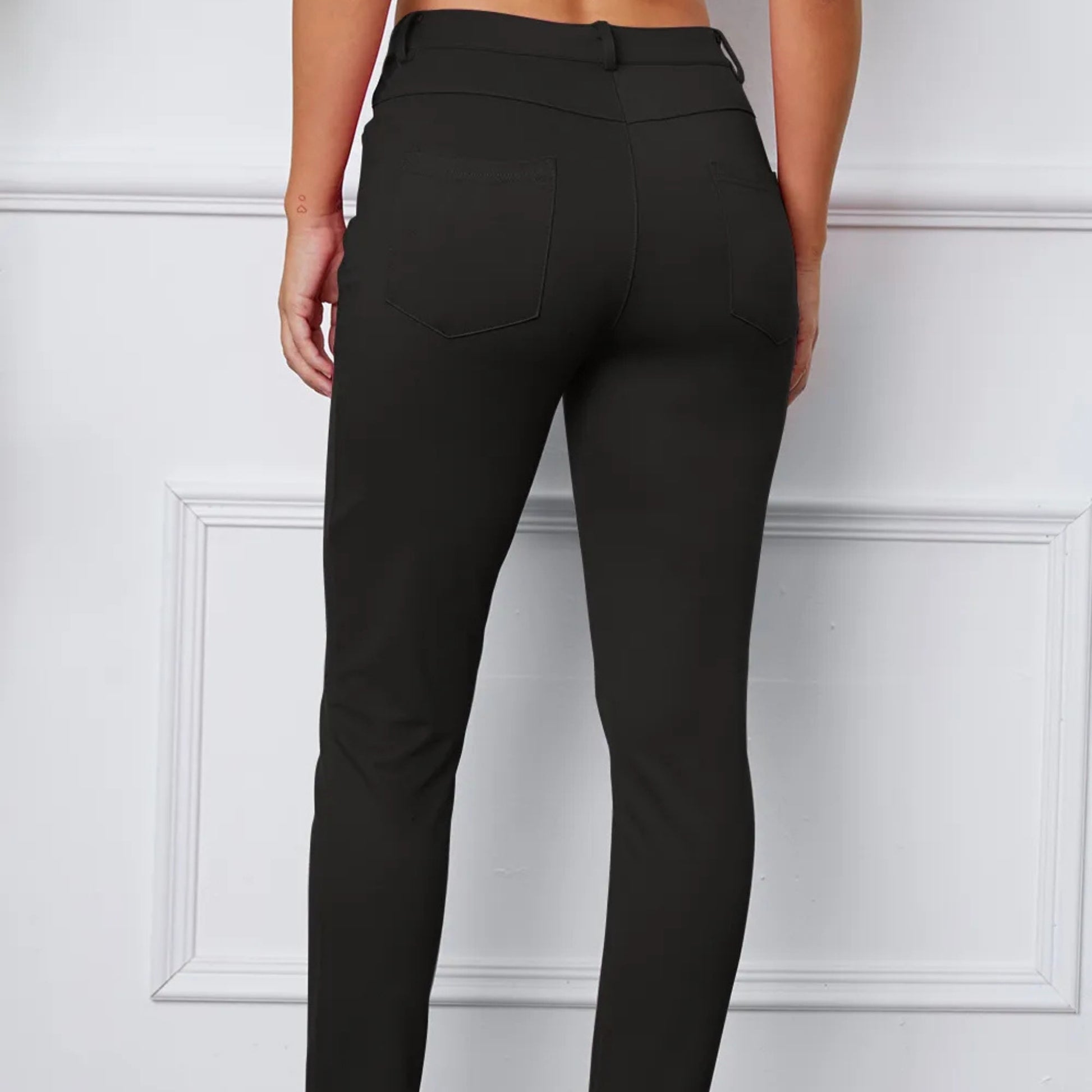 Black pants worn by a person on a white background