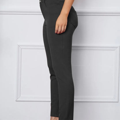 Dark grey pants worn by a person on a white background
