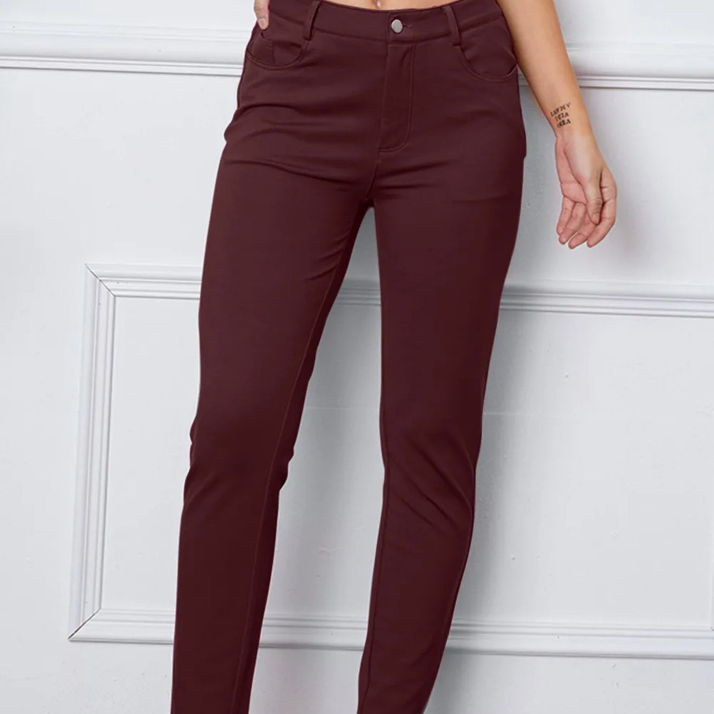 Maroon pants worn by a person against a white wall