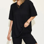 Women's black oversized lounge set featuring a relaxed V-neck short sleeve top with matching biker shorts.