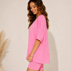 Side view of women's pink oversized lounge set featuring a loose-fit V-neck top and biker shorts.