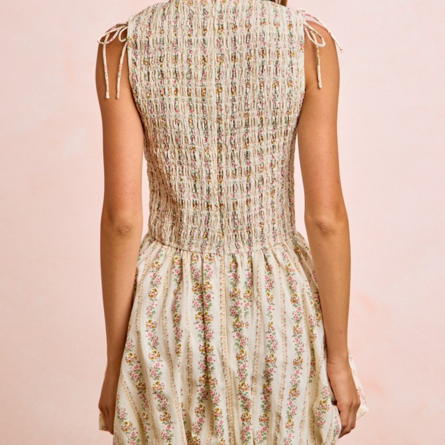 Floral dress worn by a person on a pink background