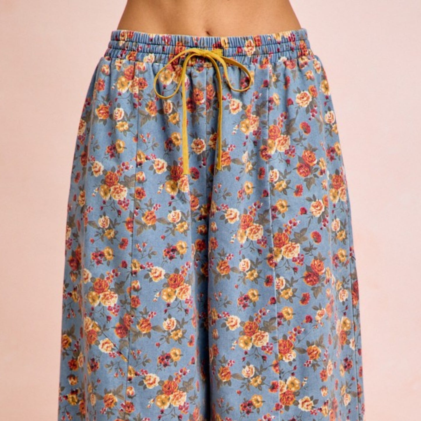 Floral patterned pants with a drawstring on a beige background