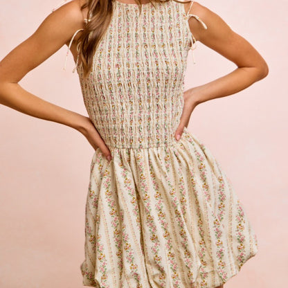 Woman wearing a floral dress against a pink background