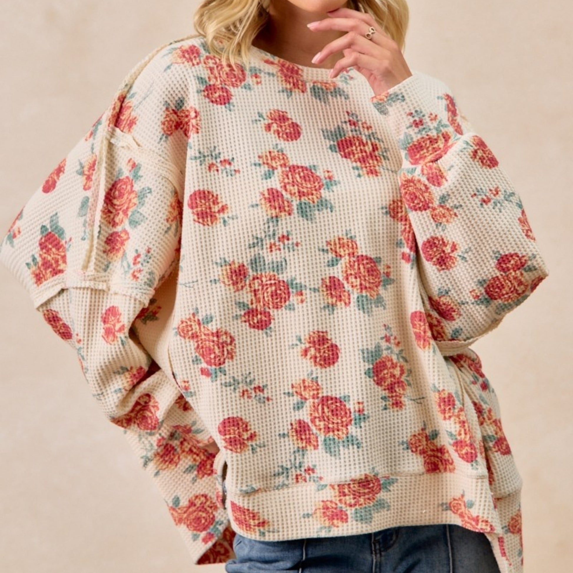 Floral patterned sweater worn by a person on a beige background