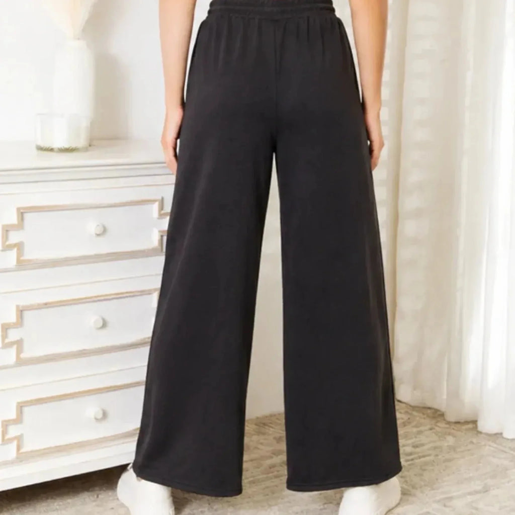 Back view of black wide leg lounge pants with a relaxed fit and elastic waistband.
