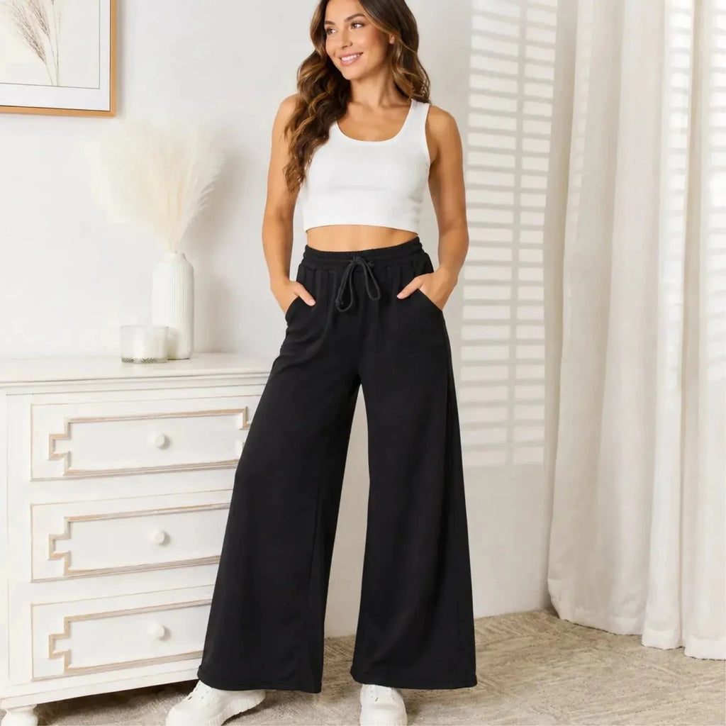 Woman wearing black drawstring wide leg lounge pants with pockets styled for a casual everyday outfit.