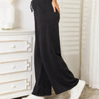 Side view of black wide leg lounge pants with a relaxed silhouette and comfortable fit.