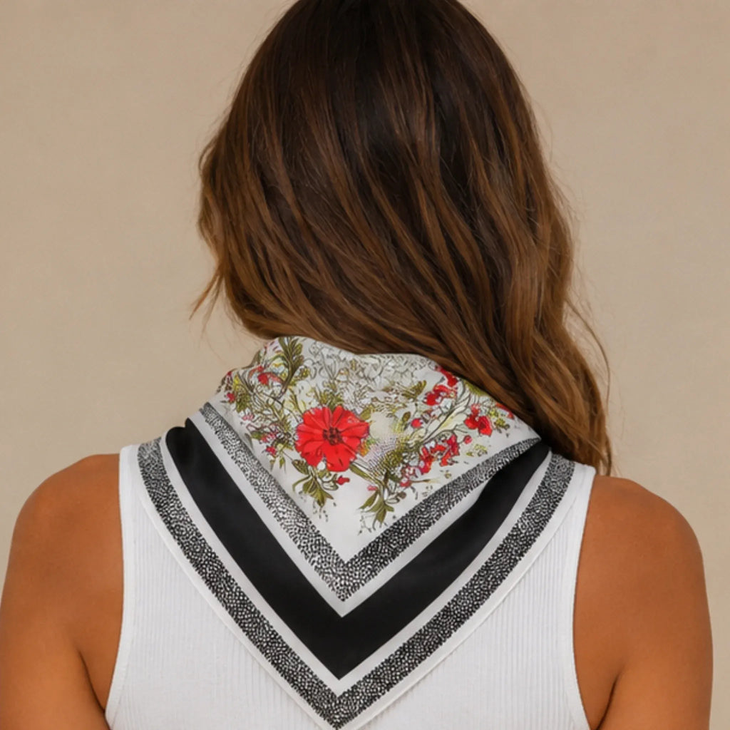 Back view of a black floral multi print square scarf draped over the shoulders showcasing the floral print and black border.
