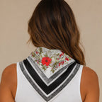 Back view of a black floral multi print square scarf draped over the shoulders showcasing the floral print and black border.