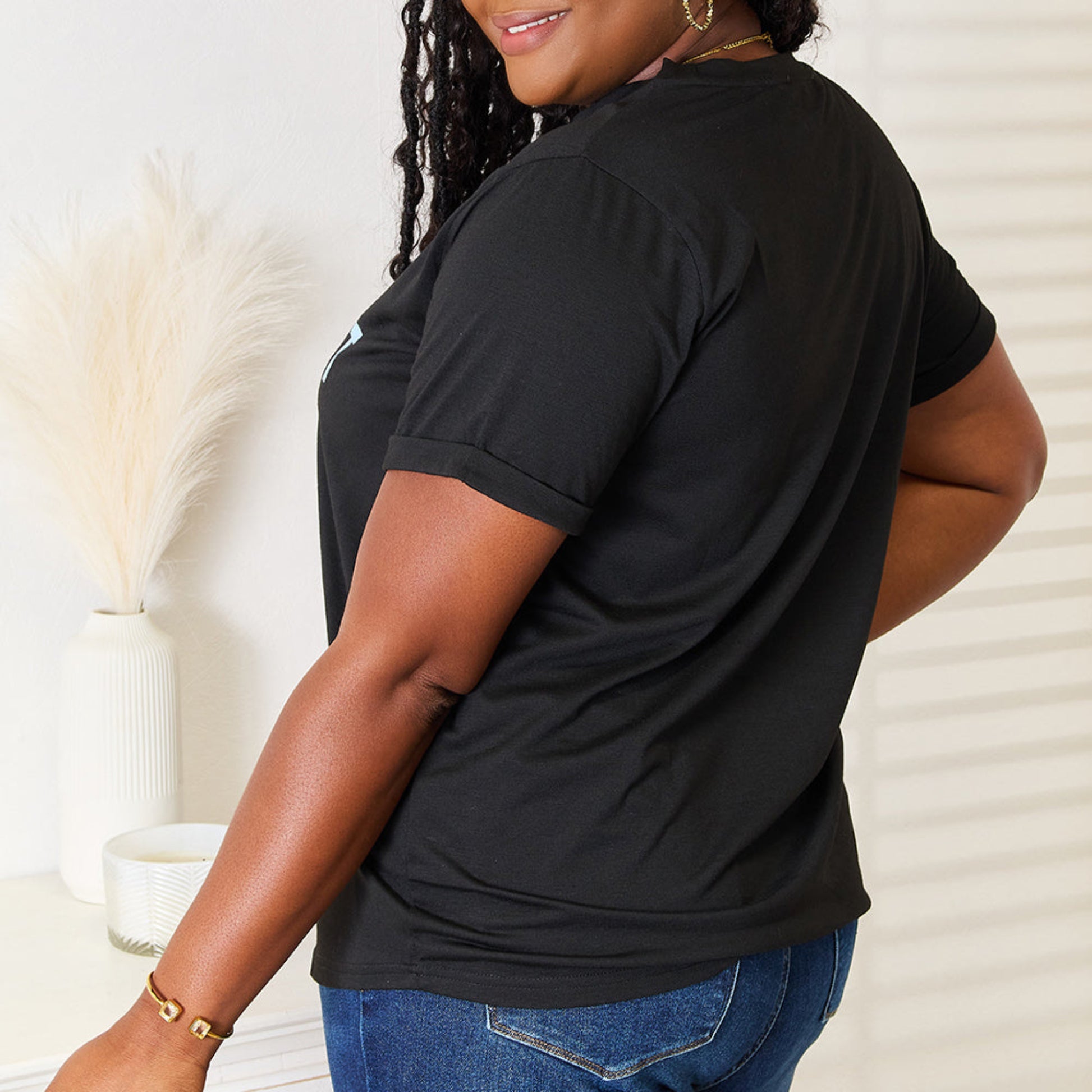 Woman wearing a cuffed sleeve slogan tee with sneakers for a casual look.