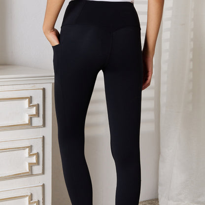Person wearing black leggings standing against a neutral background