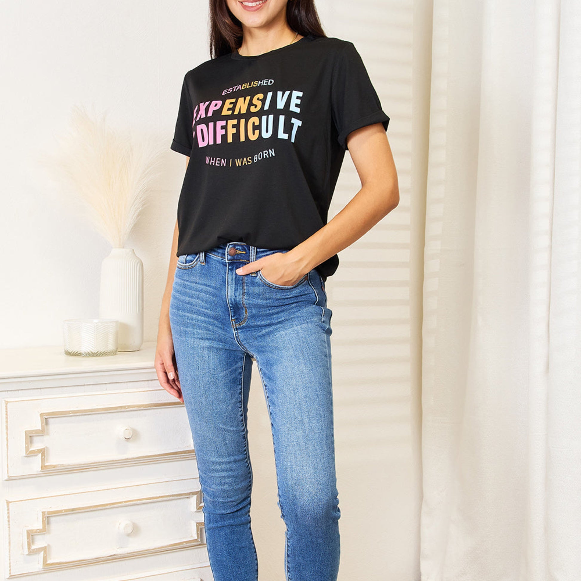 Folded black graphic t-shirt highlighting the cuffed sleeves and neck.