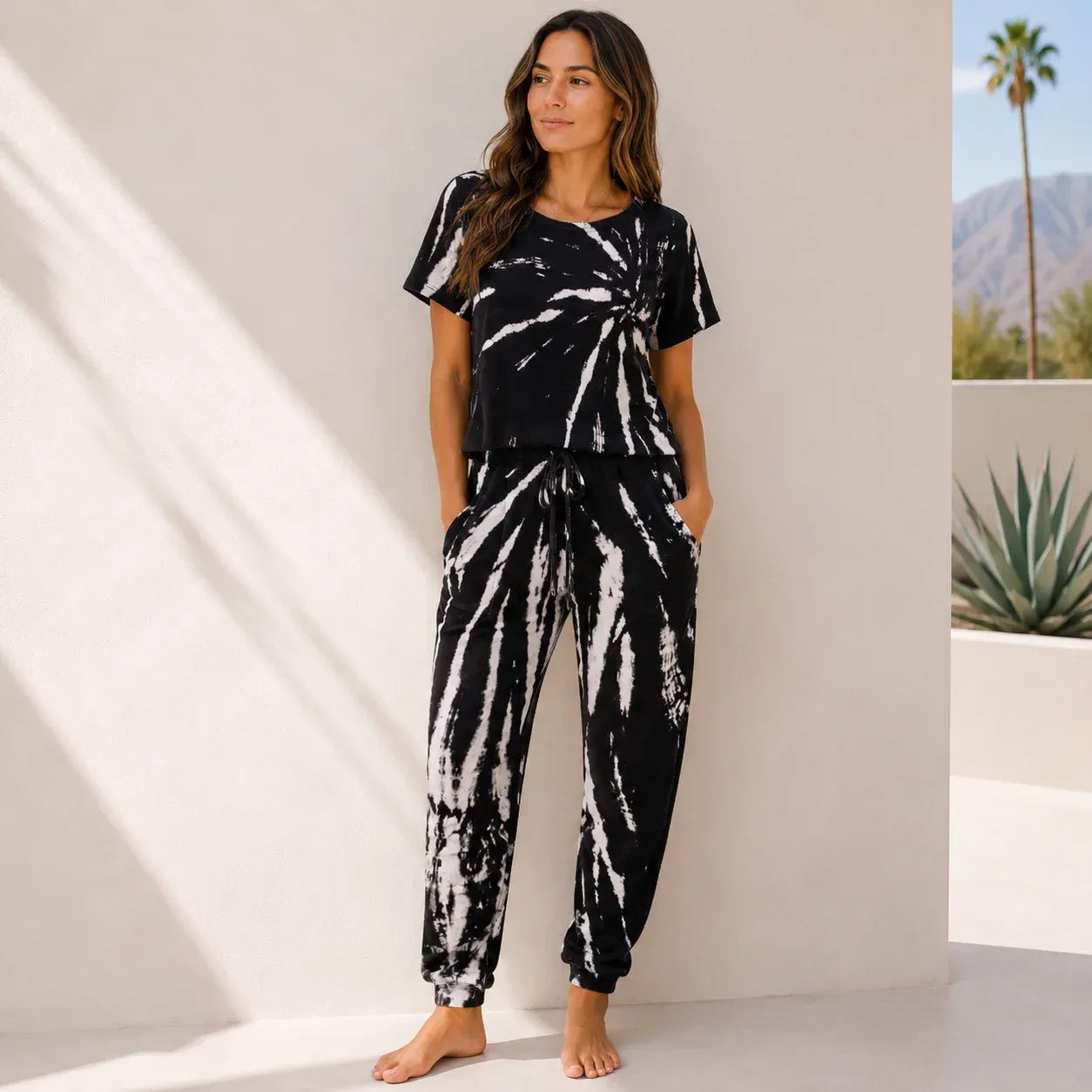 Women's black tie-dye two-piece lounge set with short sleeve top and matching jogger pants.