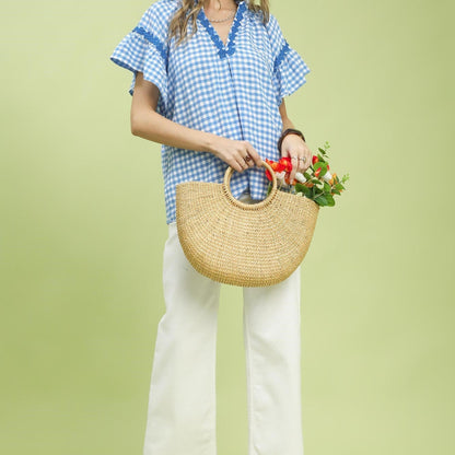 Lifestyle view of the Umgee gingham top paired with white denim for a summer look.