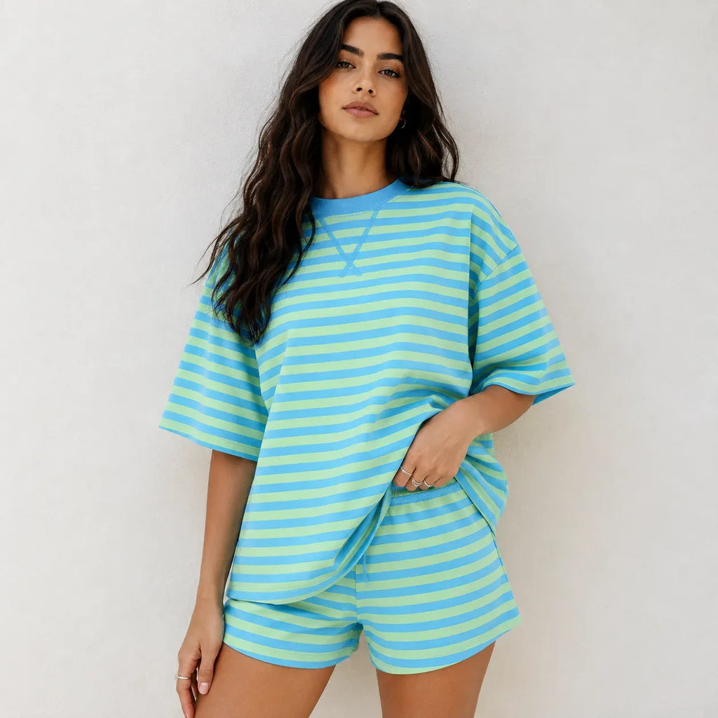 Model wearing bright blue and lime green horizontal striped oversized short-sleeve top and matching shorts lounge set