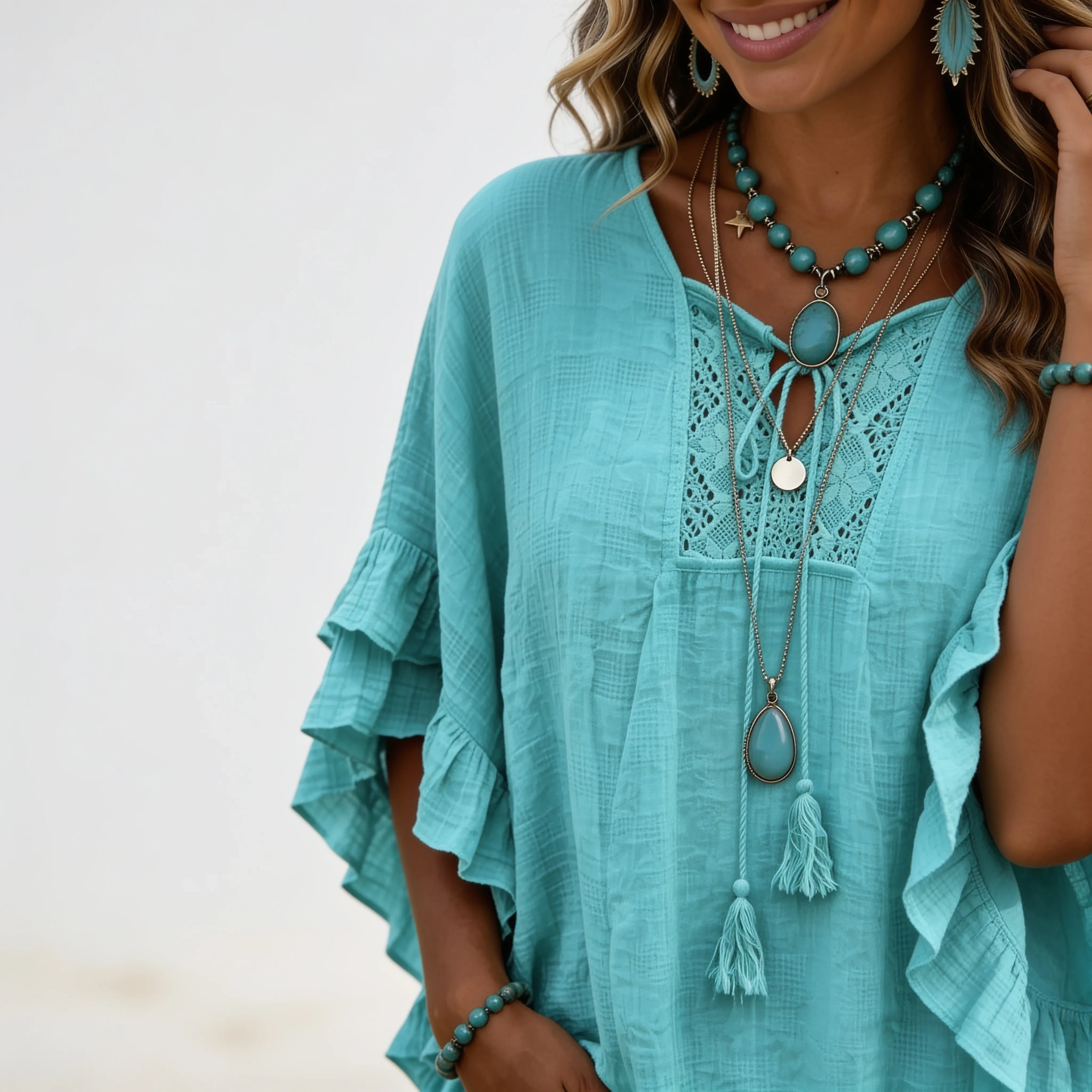 Close-up of the emerald green boho lace trim tassel tie V-neck blouse highlighting the lace inset, tassel ties, and textured woven fabric.