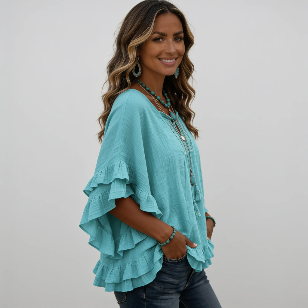 Side view of the women's emerald green boho lace trim tassel tie V-neck blouse showcasing the flowy silhouette and layered ruffle sleeves.