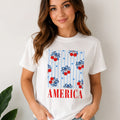 Woman wearing the Bow Cherry America Patriotic Graphic Crewneck T-Shirt in white with cherry bow patriotic print.