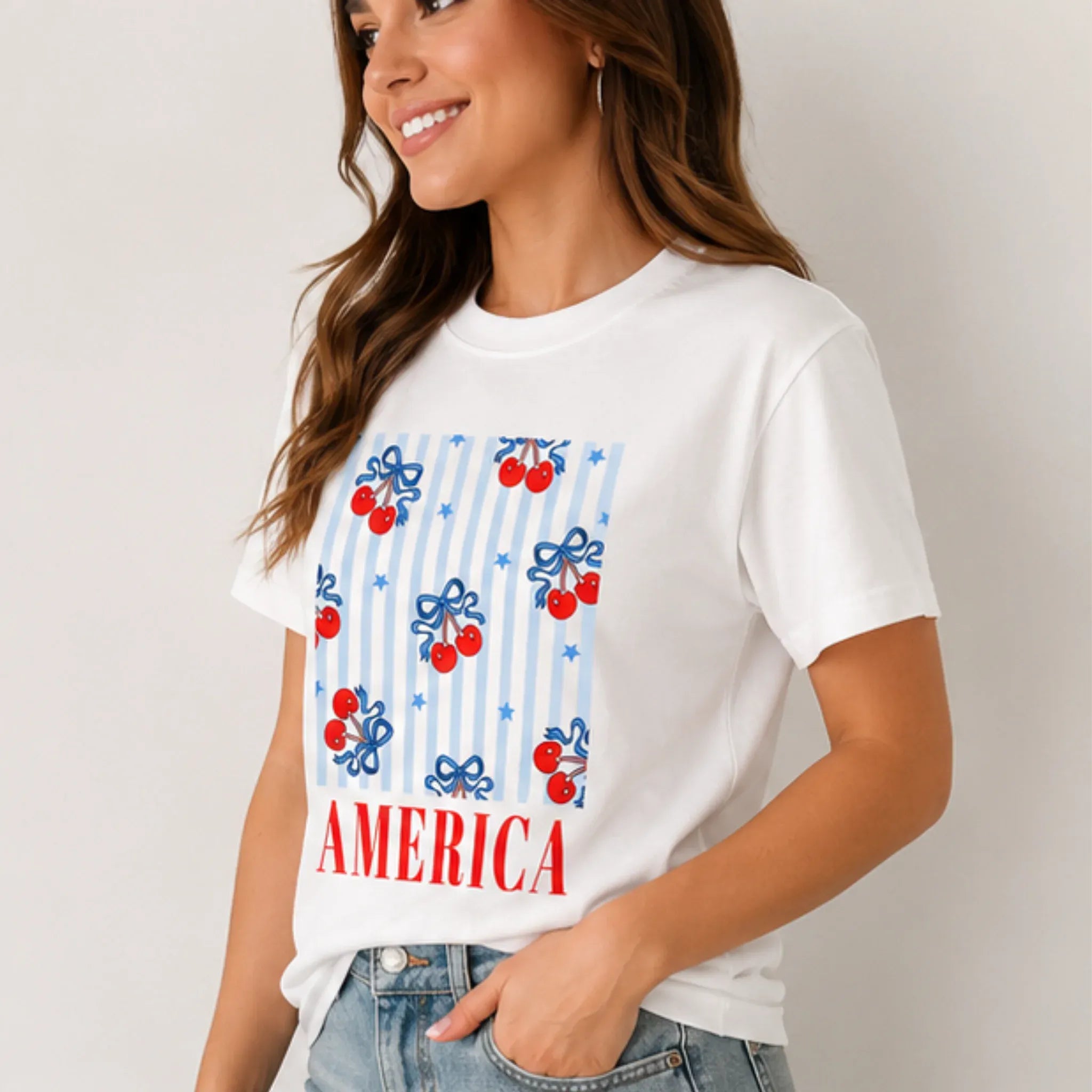 Side view of woman wearing the Bow Cherry America Patriotic Graphic Crewneck T-Shirt featuring a cherry bow America graphic.