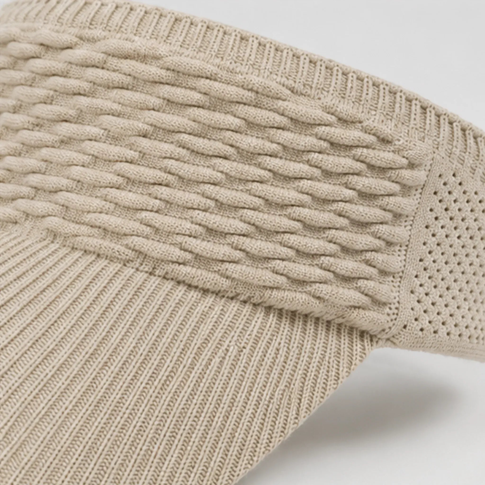 Close-up of the khaki knit sun visor highlighting the textured cable knit pattern, breathable mesh sides, and curved brim.