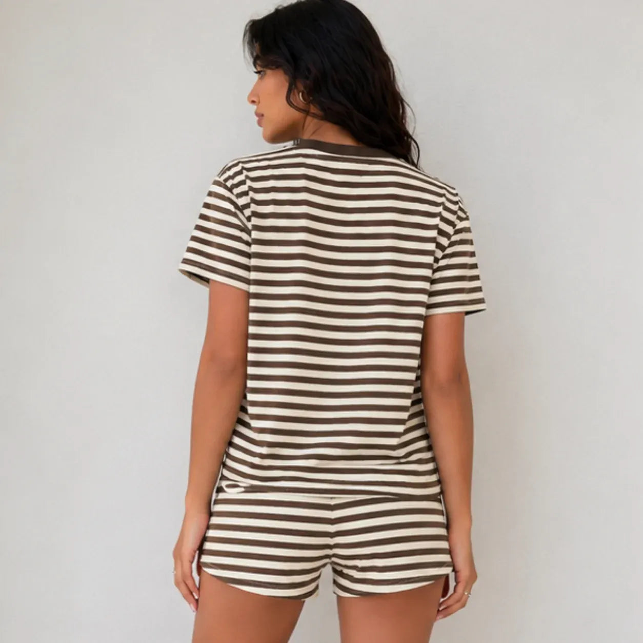 Back view of woman wearing brown and cream horizontal striped short-sleeve two-piece lounge set