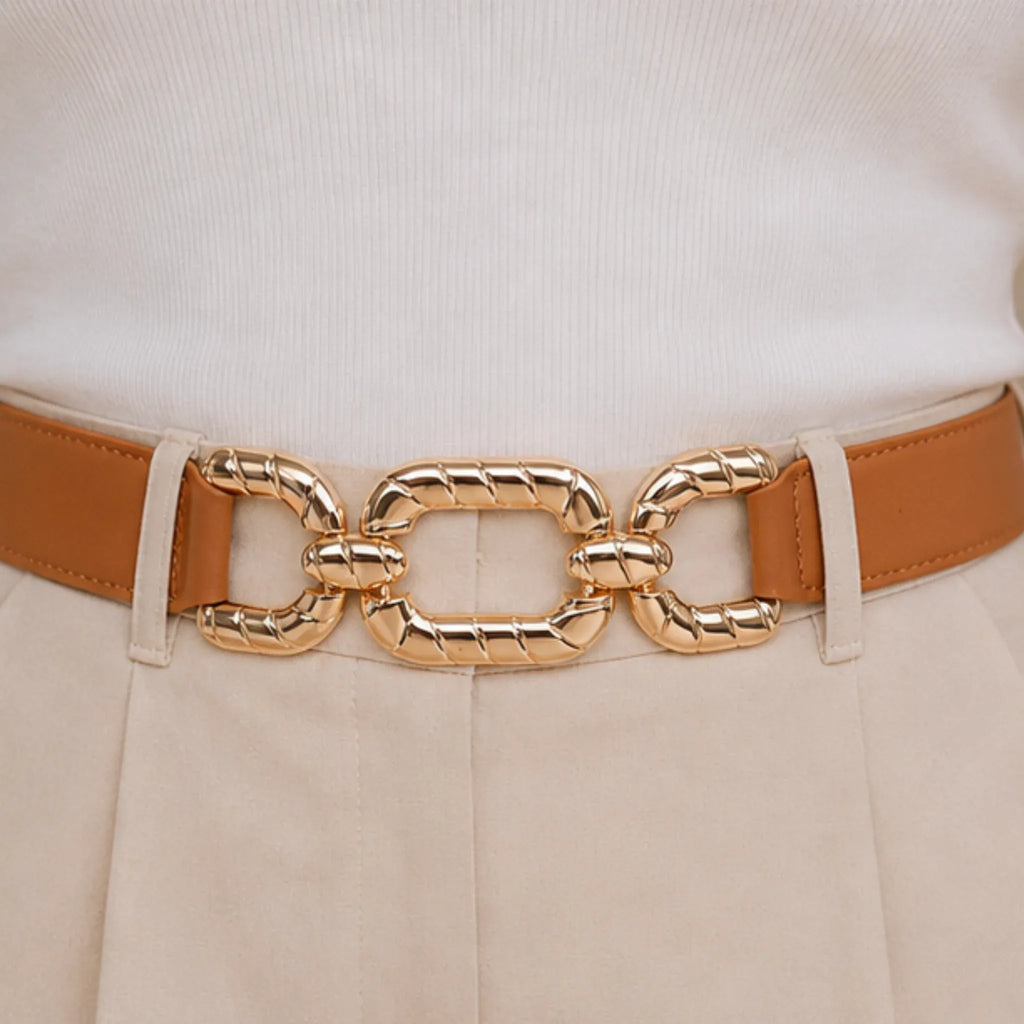 Close-up of a camel elastic waist belt featuring a textured gold chain buckle.