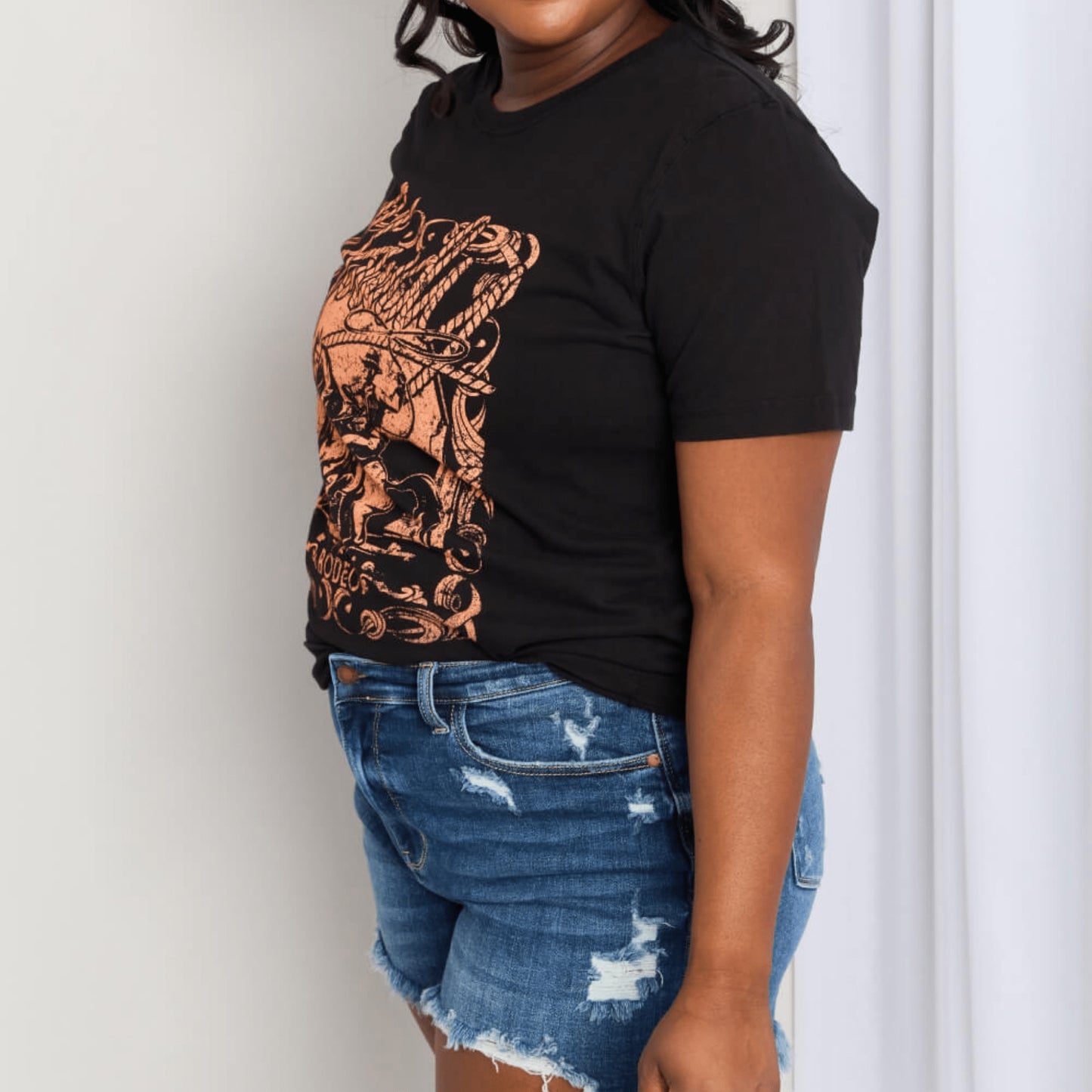 Alternative angle of the cotton graphic tee styled with denim and sunglasses.