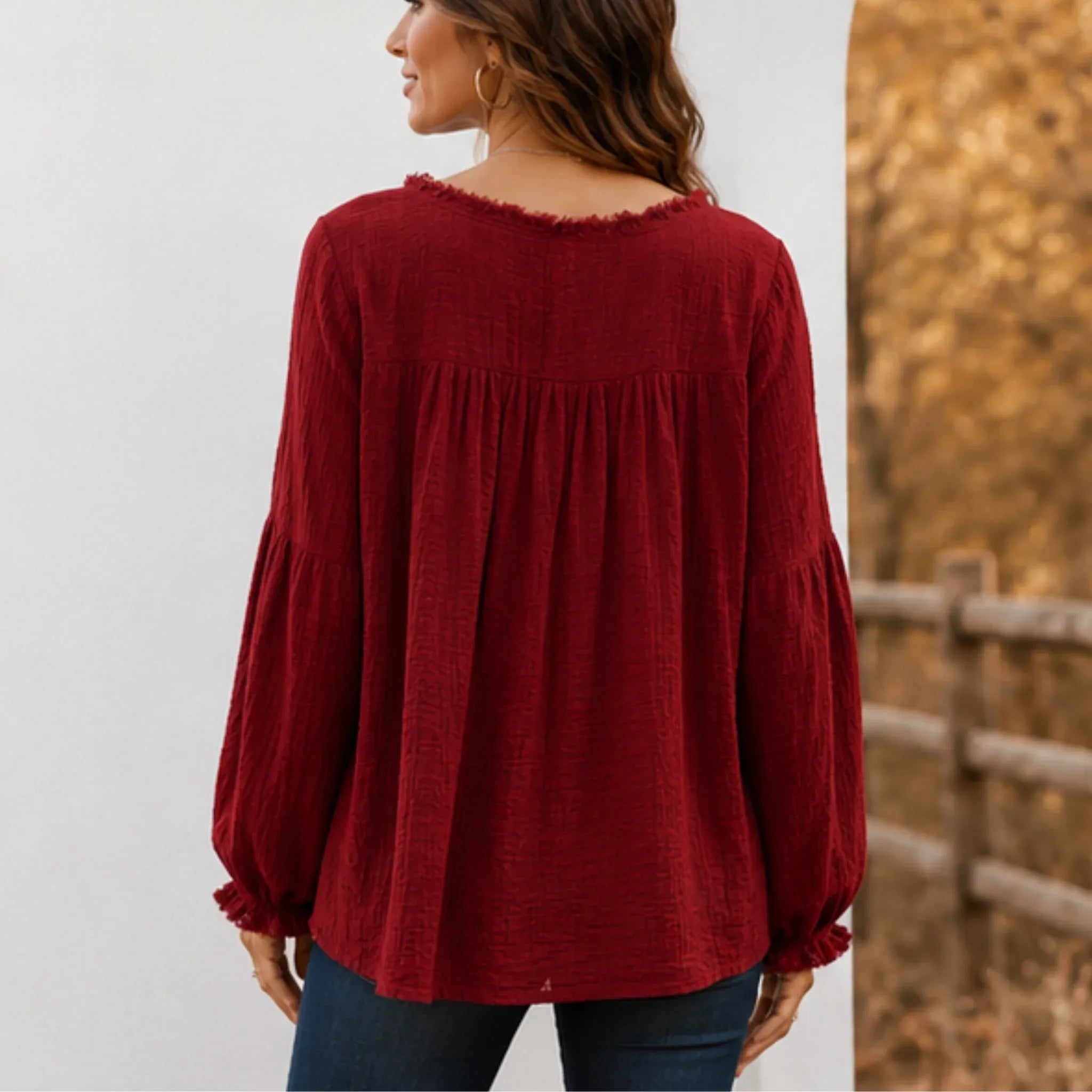 Back view of the women's wine red Casual Long Sleeve Fringe Tassel Top showcasing the relaxed babydoll silhouette, gathered back yoke, textured fabric, and long sleeves.