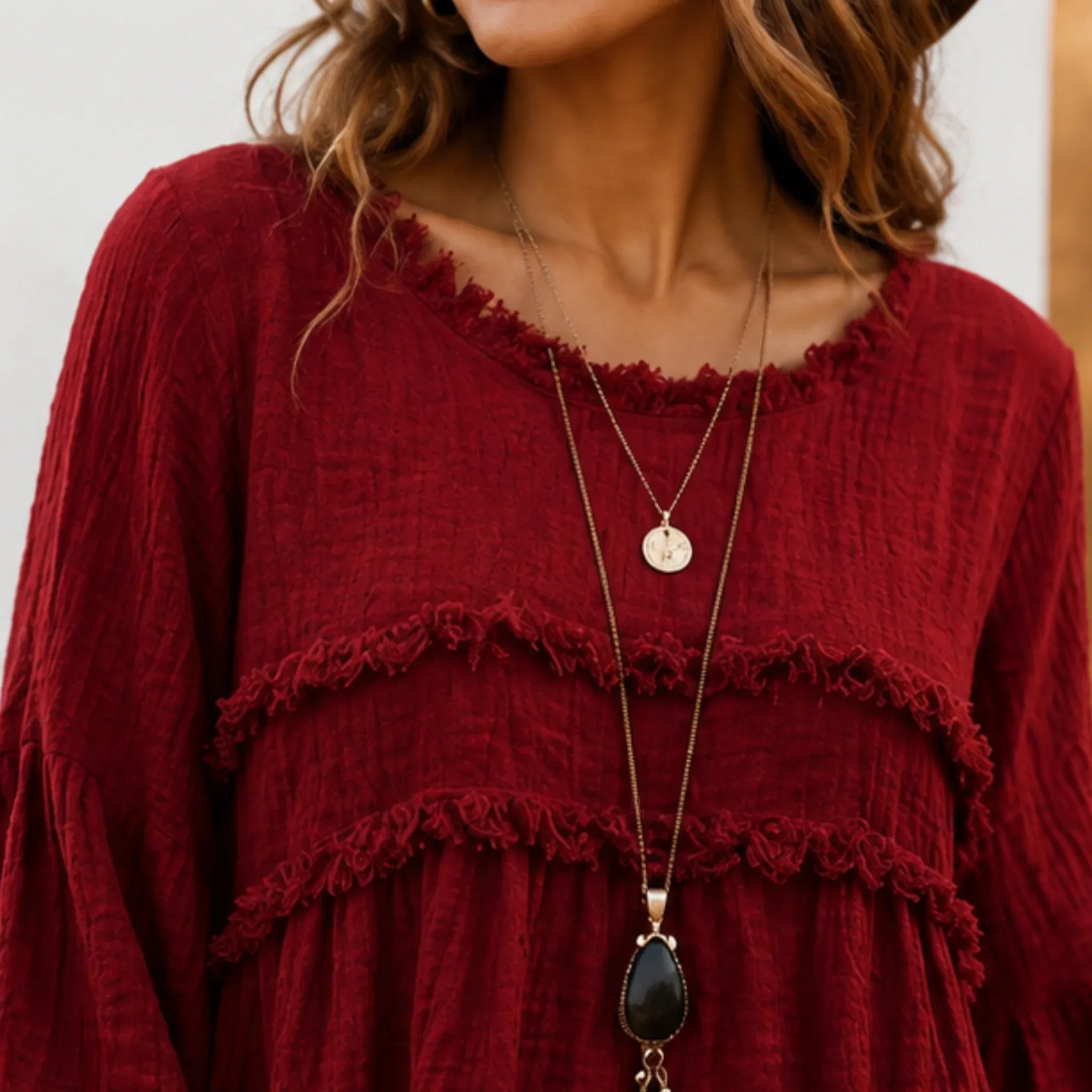 Close-up of the women's wine red Casual Long Sleeve Fringe Tassel Top highlighting the textured woven fabric, fringe tassel trim, and round neckline.