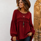 Women's wine red Casual Long Sleeve Fringe Tassel Top with textured woven fabric, fringe tassel trim, long balloon sleeves, relaxed fit, and round neckline.