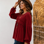 Side view of the women's wine red Casual Long Sleeve Fringe Tassel Top featuring a relaxed babydoll silhouette, textured woven fabric, fringe tassel accents, and balloon sleeves.