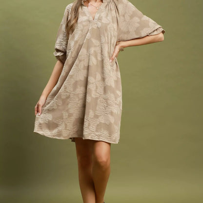 Close up detail of the flattering V-neckline and clean stitching on a taupe Umgee dress from Solazura Boutique