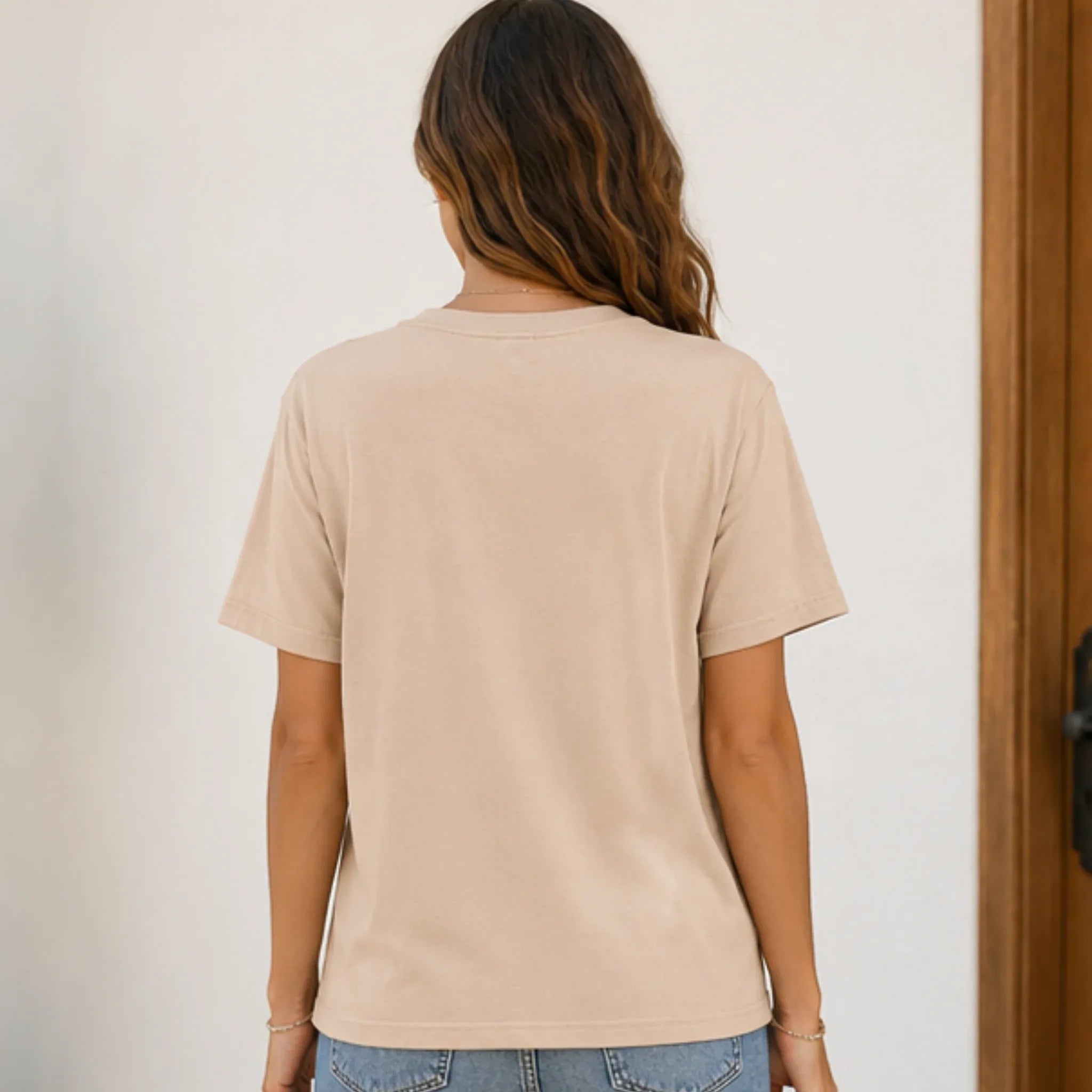 Back view of a beige Cherry Graphic Round Neck Short Sleeve T-Shirt on a woman with a relaxed fit.