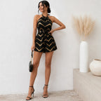 Chevron Halter Neck Romper in black featuring a metallic gold chevron print, halter neckline, self-tie waist, and relaxed fit front view.
