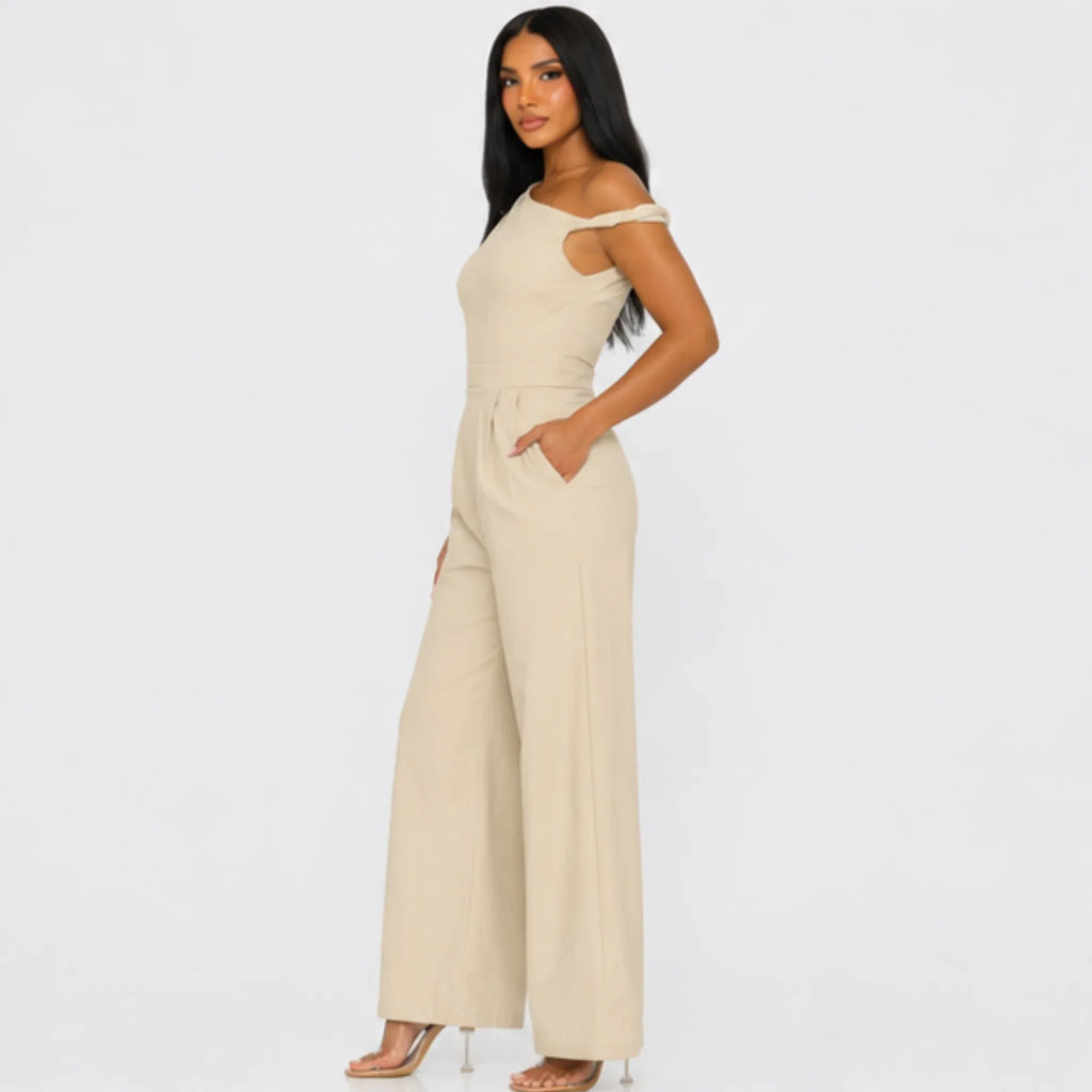 Side profile of the Chic Poise One-Shoulder Jumpsuit in stone featuring an asymmetrical neckline, tailored waist, side pockets, and wide-leg fit.