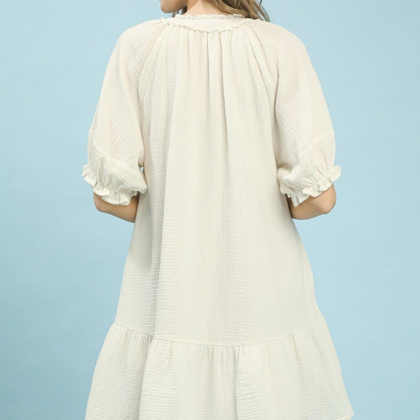 White dress with ruffled sleeves on a light blue background